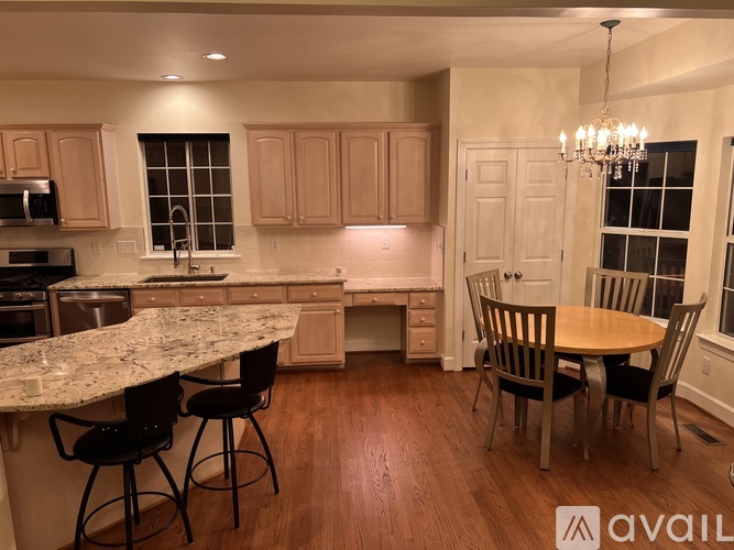 A kitchen with a marble countertop and wooden floors.
