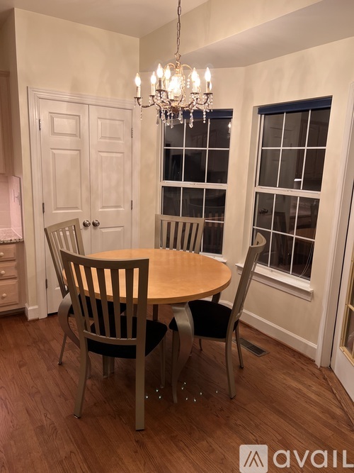 A dining room with a round table and chairs.