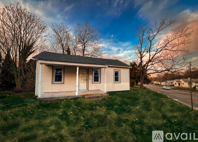 A small house with a porch is for sale.