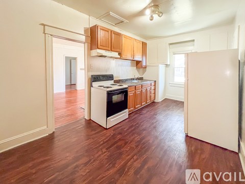A kitchen with wooden cabinets and a white stove top oven.