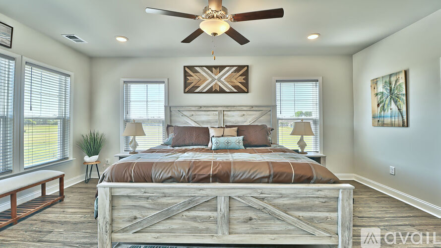 A bedroom with a large bed and a ceiling fan.