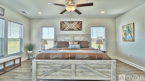 A bedroom with a large bed and a ceiling fan.