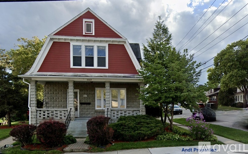 A red house with white trim and a grey front porch.