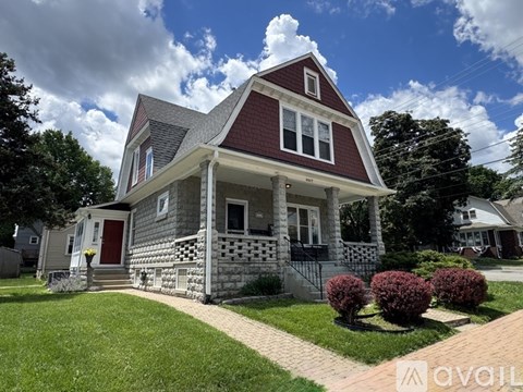 A red house with white trim and a grey front porch.