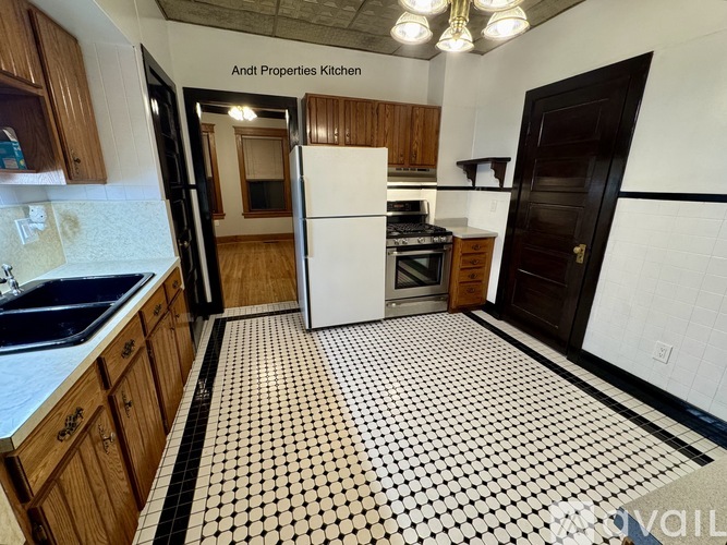 A kitchen with black and white tiles on the floor.