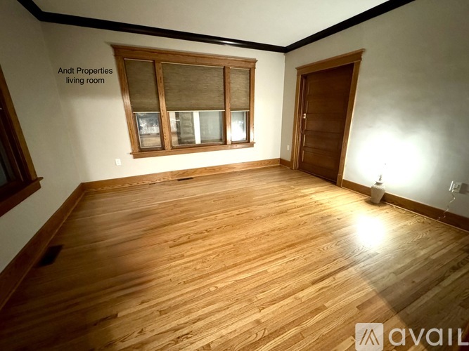 A living room with wooden floors and a window.