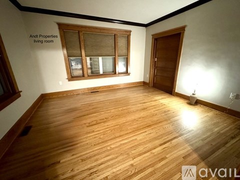 A living room with wooden floors and a window.