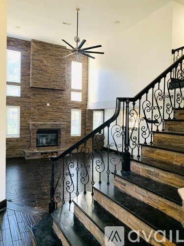 A staircase with a black metal railing and wooden steps.