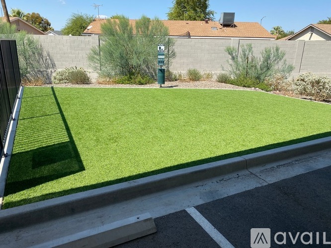 A grassy area with a green post box in the middle.