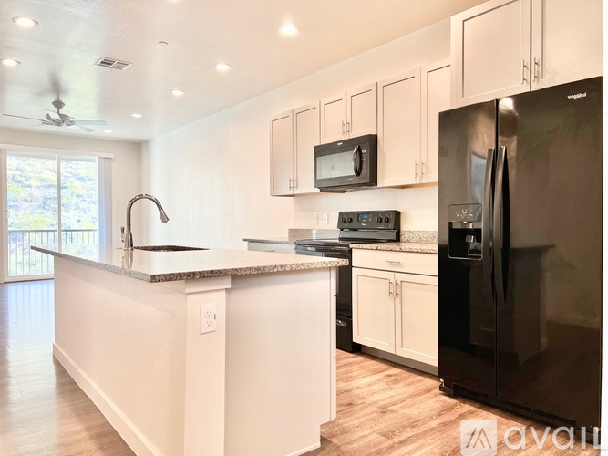 A kitchen with black appliances and white cabinets.