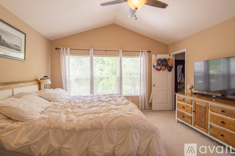 A bedroom with a large bed and a television in the corner.