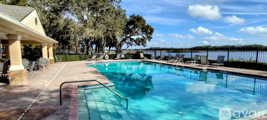 A pool with a diving board and a pavilion.