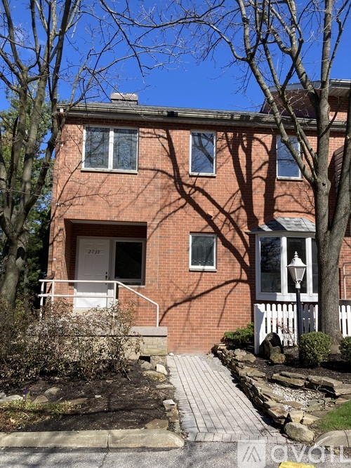 A red brick house with a white door and windows.