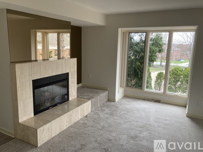 A living room with a fireplace and a carpeted floor.