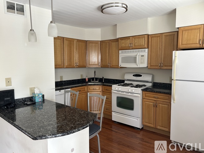 A kitchen with a white stove top oven and a white refrigerator.