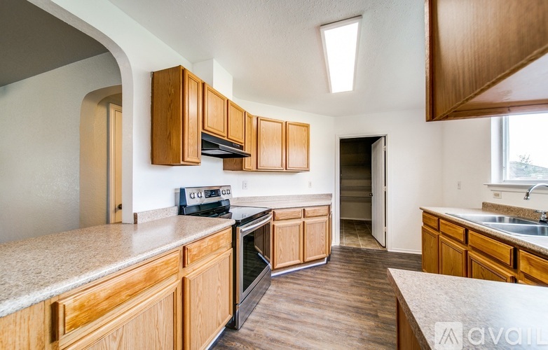 A kitchen with wooden cabinets and a black stove top oven.