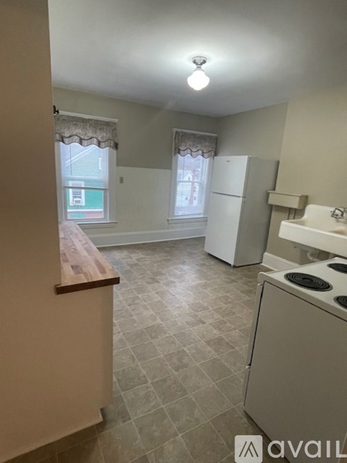 A kitchen with a stove, refrigerator, and cabinets.
