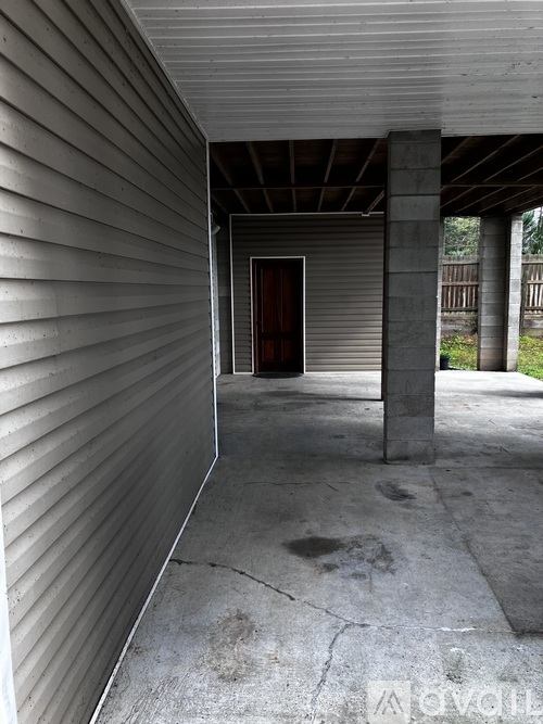 A concrete porch with a doorway leading to a backyard.