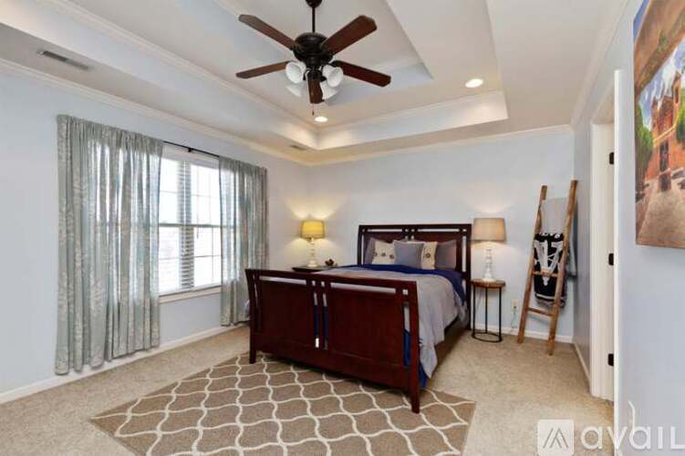 A bedroom with a large bed and a ceiling fan.