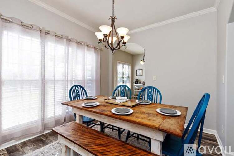A dining room with a wooden table and blue chairs.