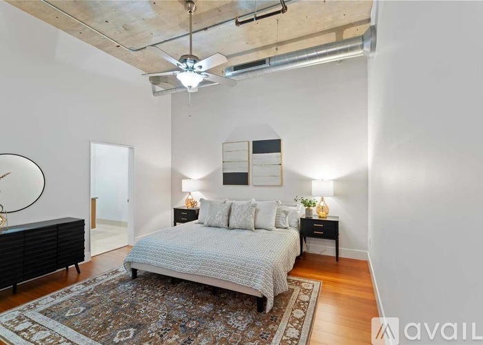 A bedroom with a bed, nightstands, and a rug.