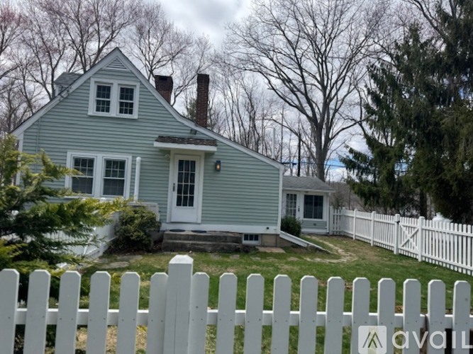 A house with a white picket fence in front.