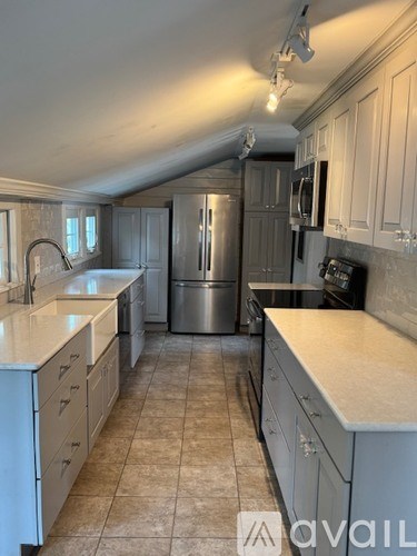A kitchen with white cabinets and a tiled floor.