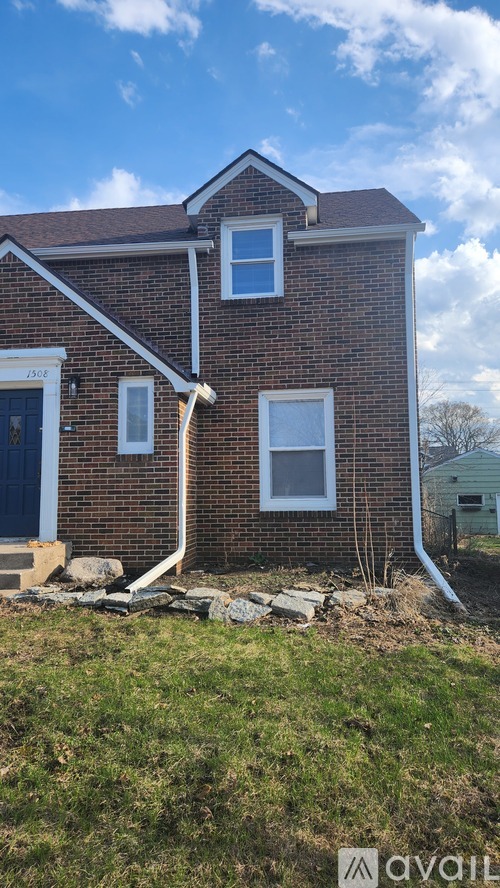A house with a blue sky and clouds in the background.