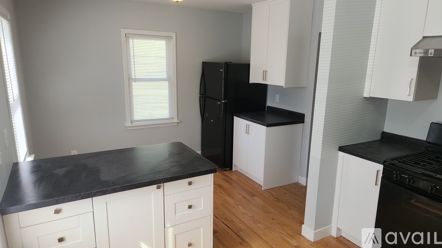 A kitchen with black countertops and white cabinets.