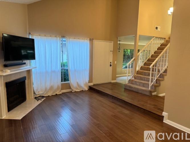 A living room with a fireplace and a television on a stand.