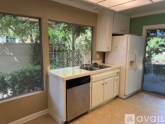 A kitchen with white appliances and cabinets is available for rent.