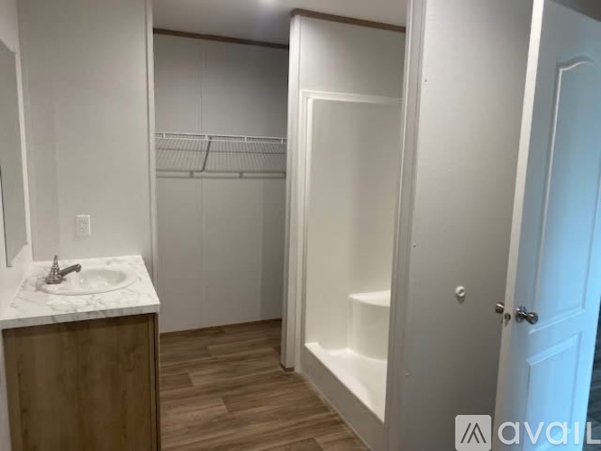 A bathroom with a sink, mirror, and walk-in shower.