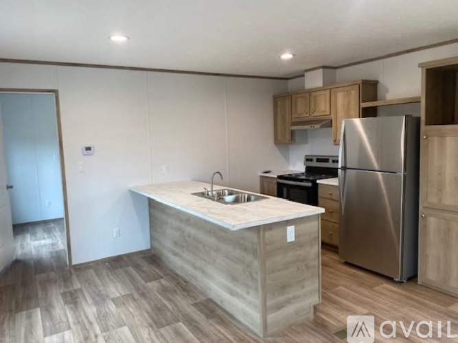 A kitchen with a sink, stove, and refrigerator.