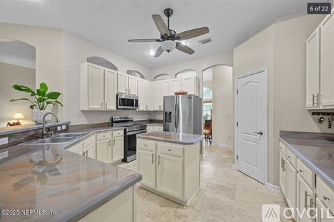 A kitchen with a fan and a plant on the counter.