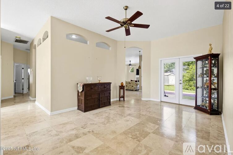 A spacious room with a ceiling fan and a cabinet.