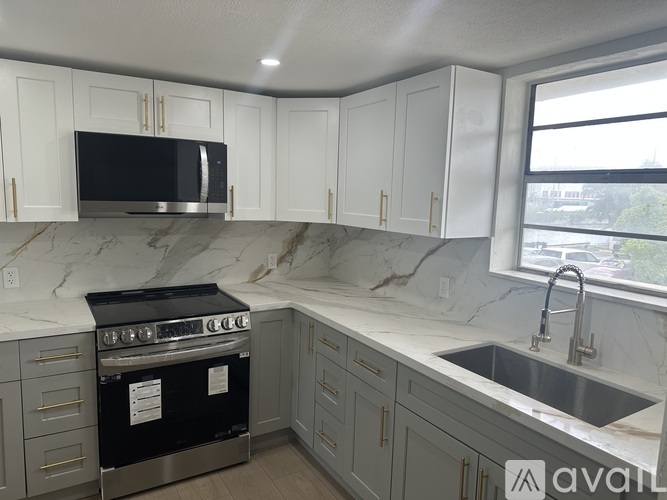 A kitchen with a black oven and a marble countertop.