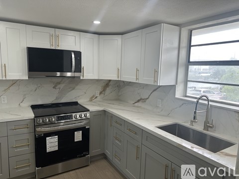A kitchen with a black oven and a marble countertop.