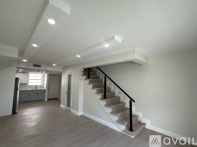 A spacious living room with a staircase leading to the upper floor.