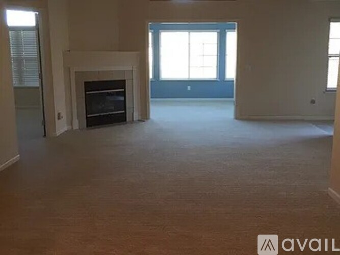 A living room with a fireplace and a large window.