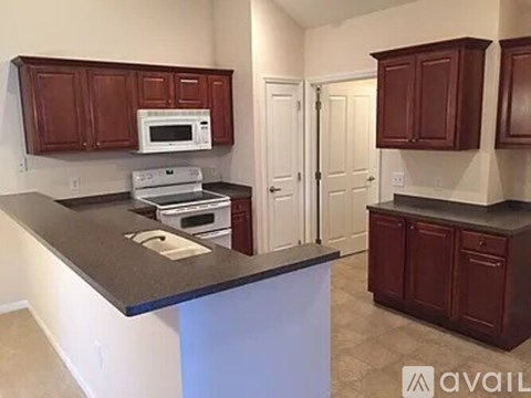 A kitchen with brown cabinets and a black countertop.