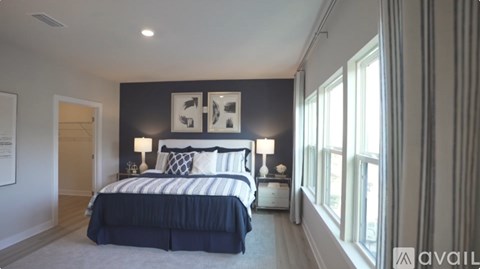 A bedroom with a large bed and two lamps.
