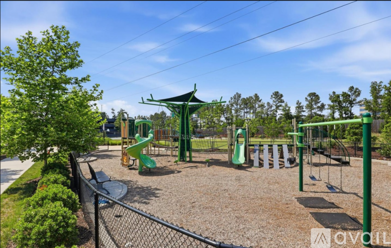 A playground with a green slide and a swing set.