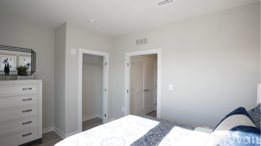 A bedroom with a bed, dresser, and mirror.