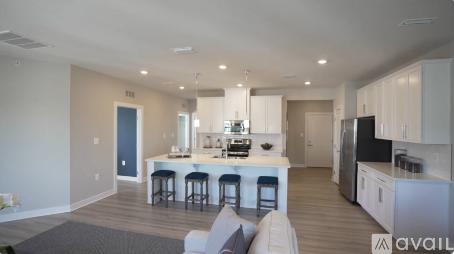 A modern kitchen with a bar and stools is available for rent.