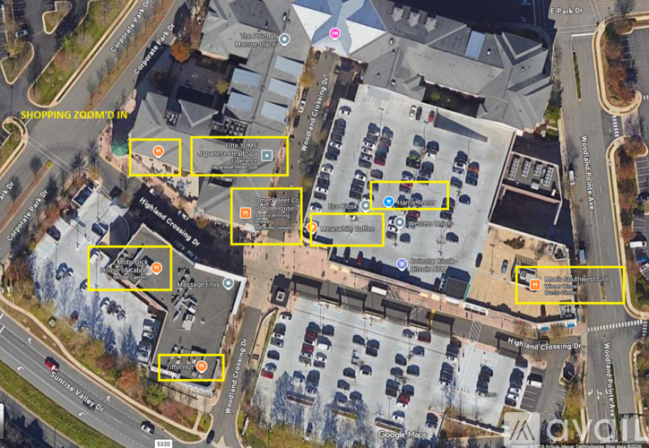 A satellite image of a parking lot and buildings with several marked areas.
