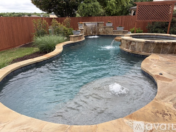 A small round pool with a waterfall in the middle.