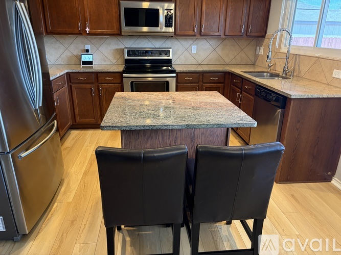 A kitchen with a table and chairs in the foreground.