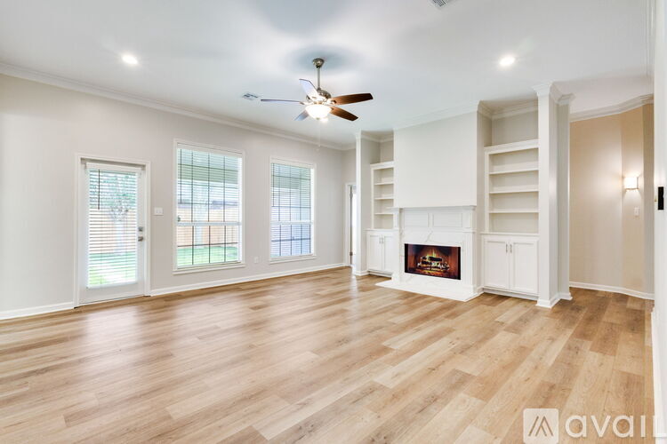 A spacious living room with a fireplace and built-in shelves.