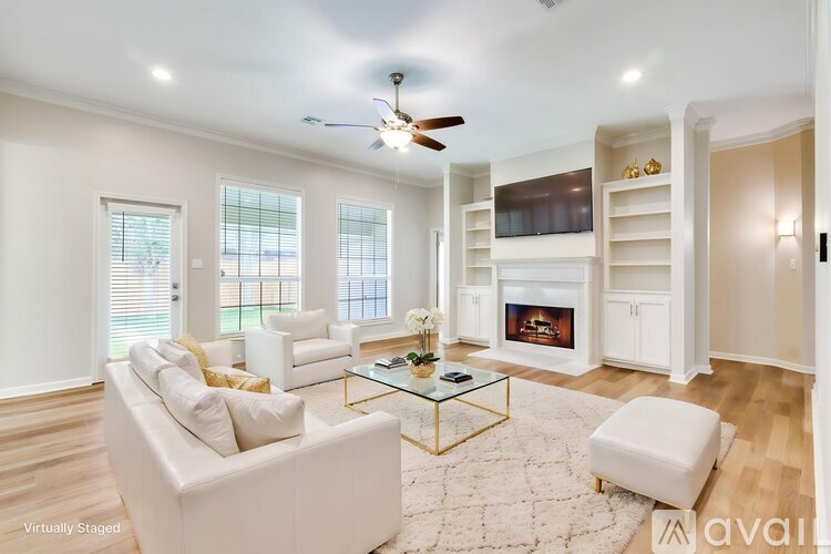 A living room with a white couch, a glass coffee table, and a fireplace.