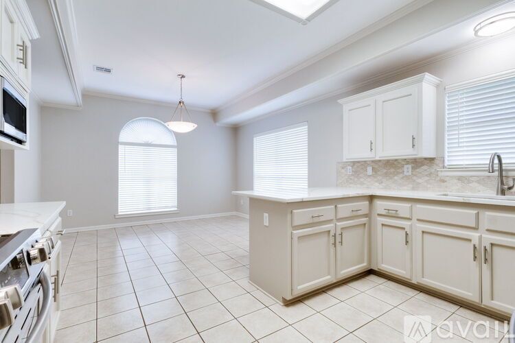 A kitchen with white cabinets and appliances.
